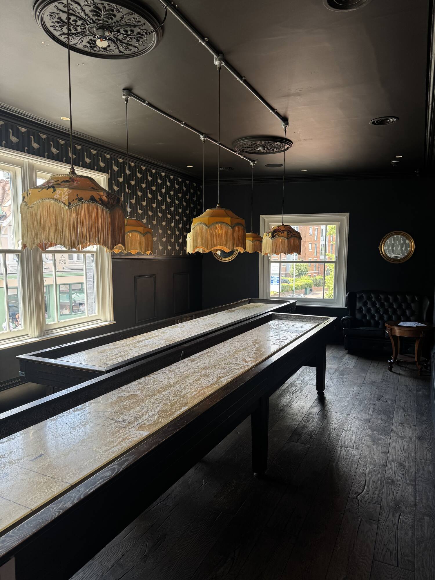 Shuffleboard tables running beneath the festoon-lit ceiling and banquette seating