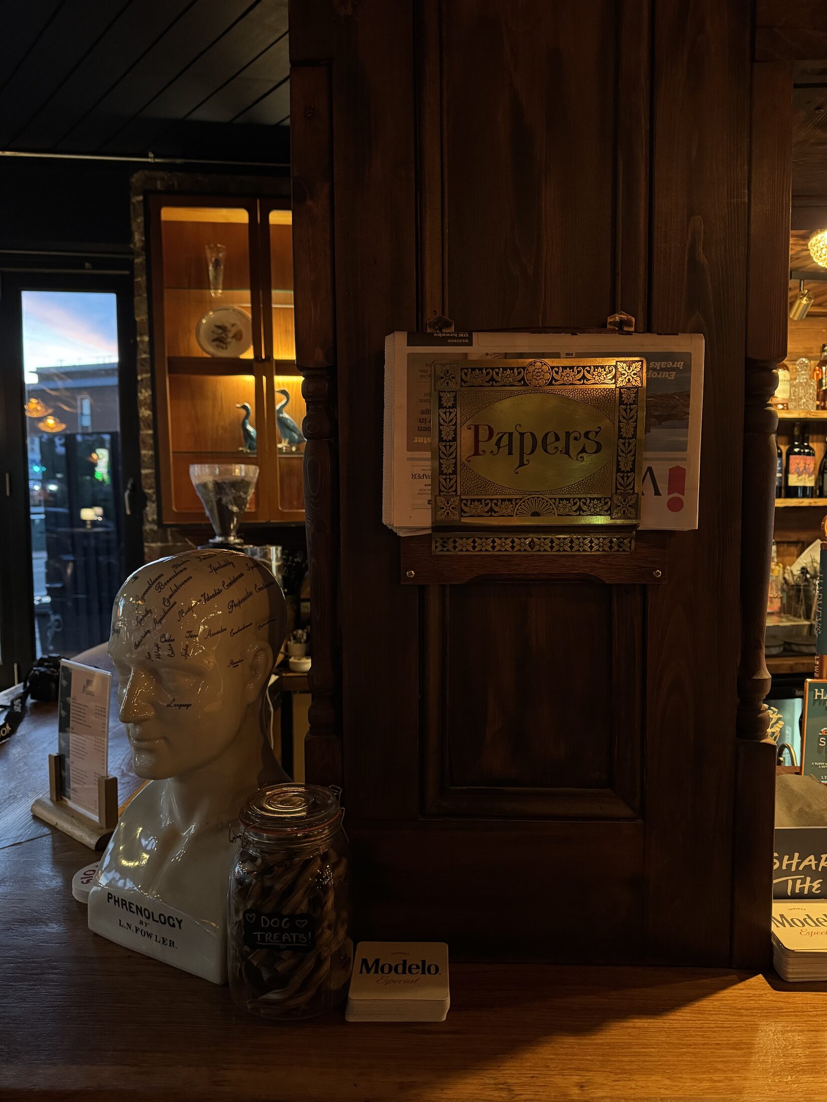 Bar detail with newspapers, wood panelling and vintage ornaments